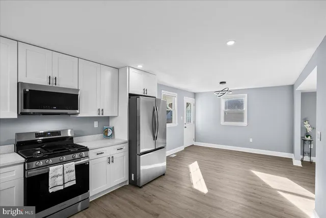 a kitchen with stainless steel appliances a stove a microwave a sink and cabinets