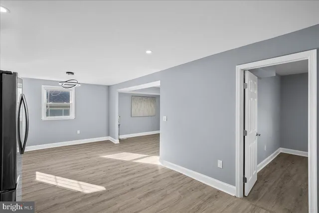 an empty room with wooden floor and a window