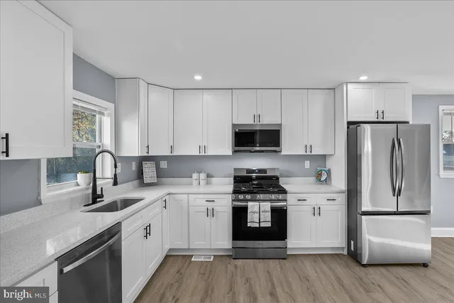 a kitchen with white cabinets and stainless steel appliances