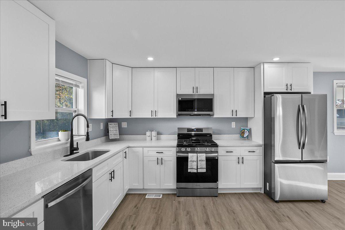 57 Transverse Avenue Middle River, MD 21220 - Photo 24 of 35 a kitchen with white cabinets and stainless steel appliances