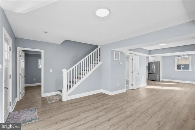 a view of a hallway with wooden floor and staircase