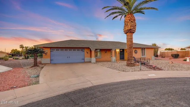 a front view of a house with palm trees