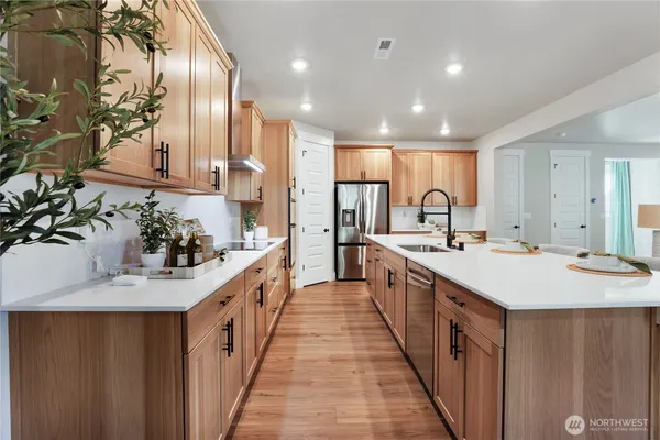 a large kitchen with kitchen island a sink a stove and a refrigerator