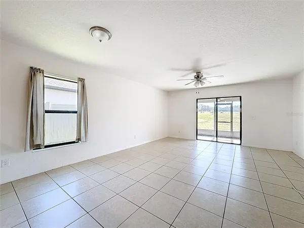 an empty room with windows and cabinet