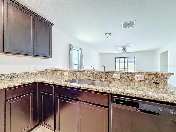 a kitchen with granite countertop cabinets sink and window