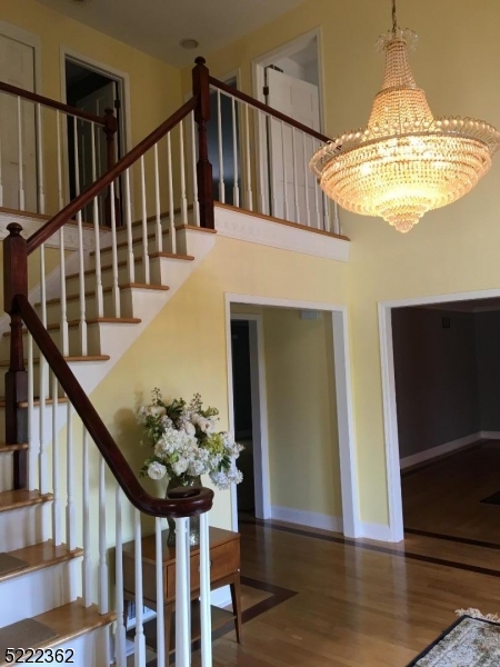 87 Highland Circle Berkeley Heights, NJ 07922 - Photo 2 of 11 a view of staircase with wooden floor and chandelier