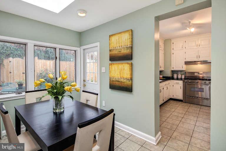 2113 37th Street Northwest Washington, DC 20007 - Photo 12 of 30 a kitchen with stainless steel appliances a sink a counter top space cabinets and a dining table