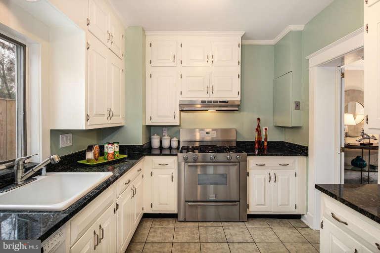 2113 37th Street Northwest Washington, DC 20007 - Photo 8 of 30 a kitchen with stainless steel appliances granite countertop a sink stove and cabinets