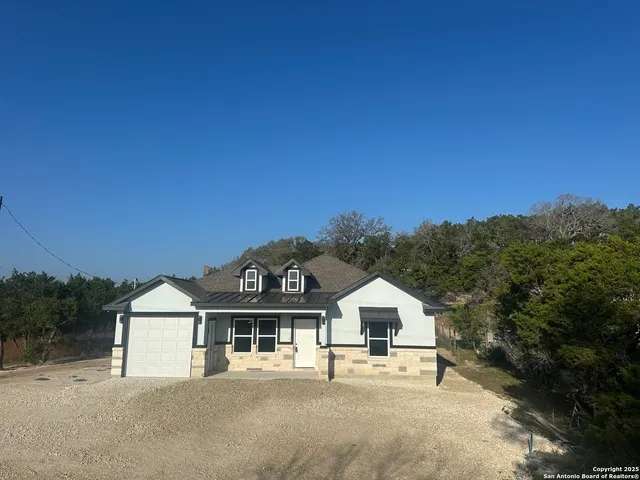 a front view of a house with a garden and yard