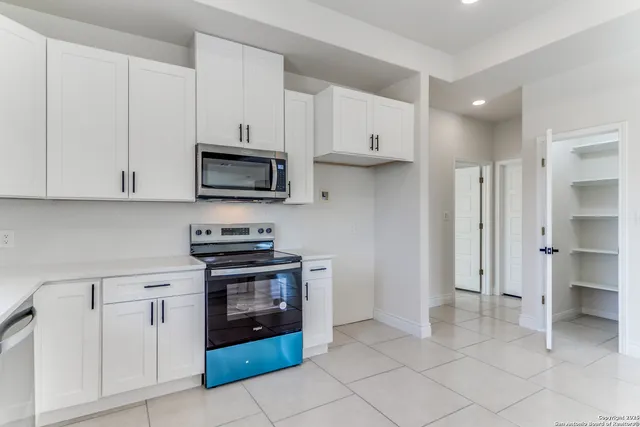 a sink with white cabinets