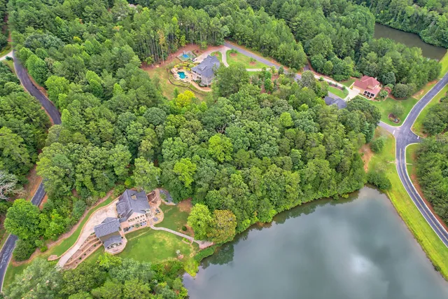 an aerial view of a house with a yard and outdoor seating