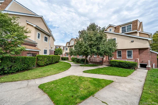 a front view of a house with a yard and potted plants