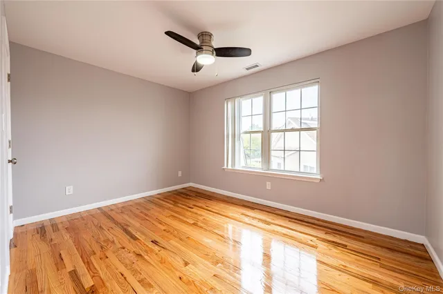 a view of a big room with wooden floor and windows