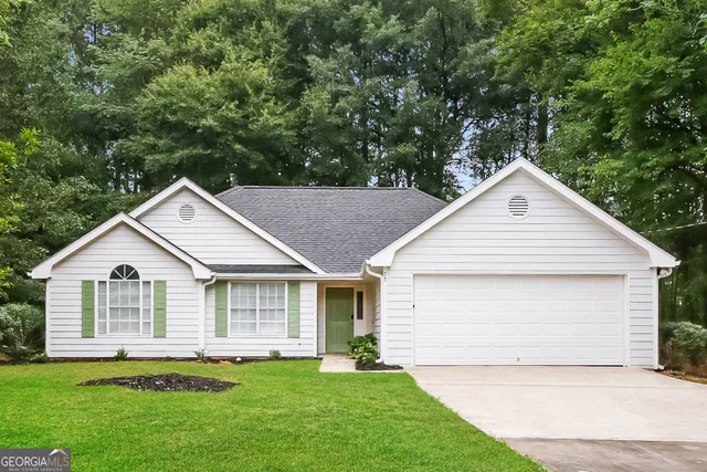 a view of a house with a yard and garage