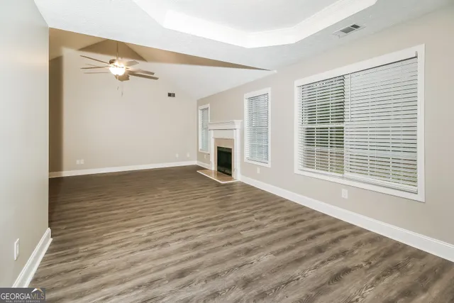 a view of empty room with wooden floor and fireplace