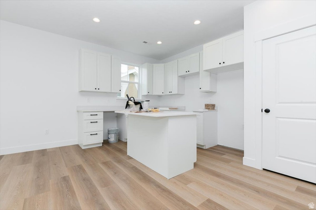 314 North 200 West Logan, UT 84321 - Photo 33 of 37 Kitchen featuring white cabinets, light wood-type flooring, light countertops, recessed lighting, and a center island