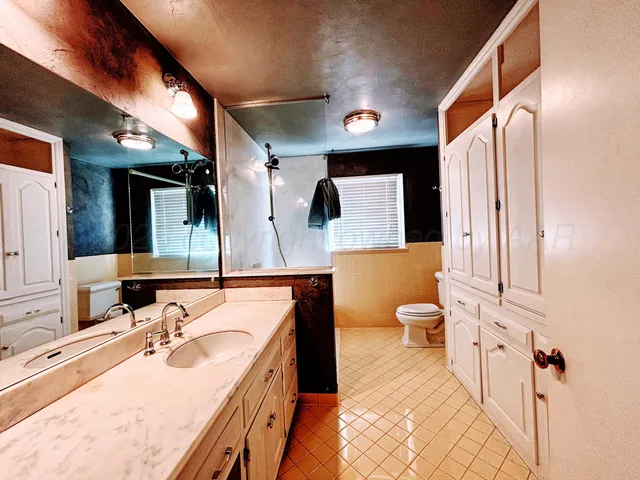 a white toilet sitting next to a bathroom sink
