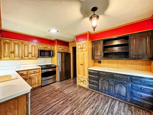 a kitchen with stainless steel appliances a refrigerator and a stove top oven