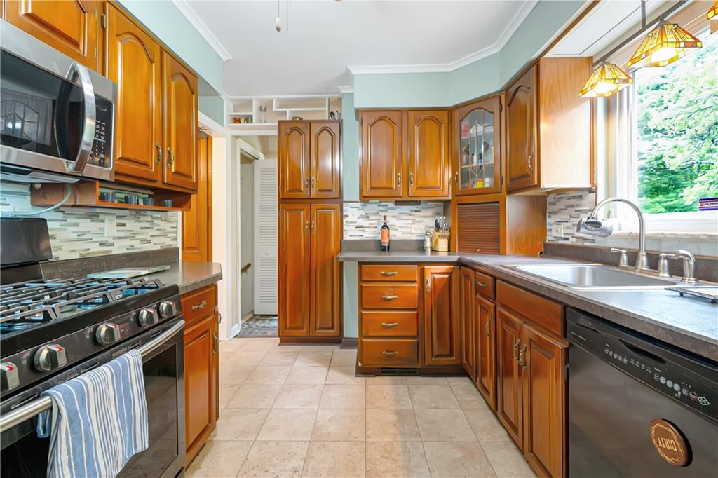 166 Spring Grove Road Pittsburgh, PA 15235 - Photo 17 of 41 a kitchen with stainless steel appliances a stove sink and cabinets