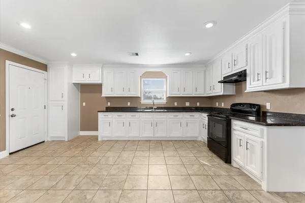 a kitchen with granite countertop white cabinets and appliances