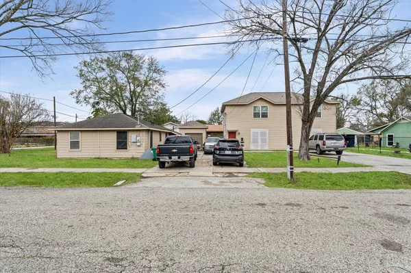a view of a house with a yard and large trees