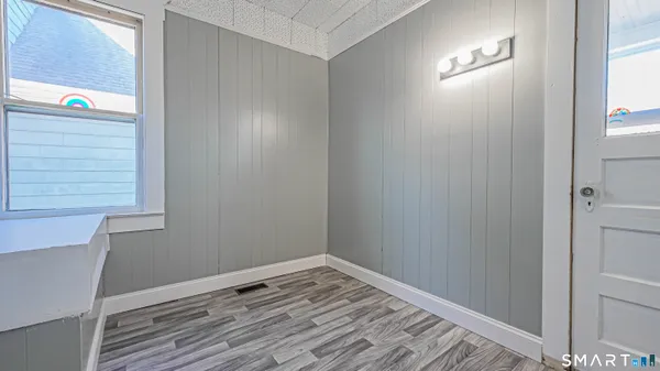 a view of empty room with window and wooden floor