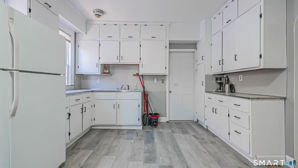 a kitchen with white cabinets and white appliances