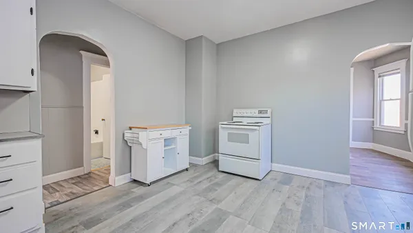 a view of a kitchen with white cabinets and wooden floor