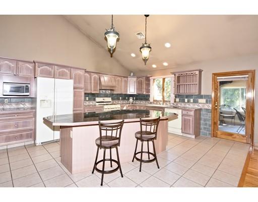 163 Gammons Road Acushnet, MA 02743 - Photo 6 of 22 a kitchen with stainless steel appliances a table chairs and a refrigerator