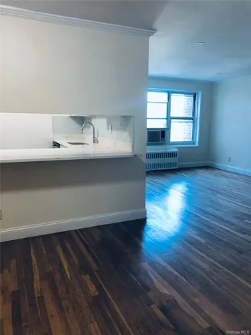 a view of a room with wooden floor and a window