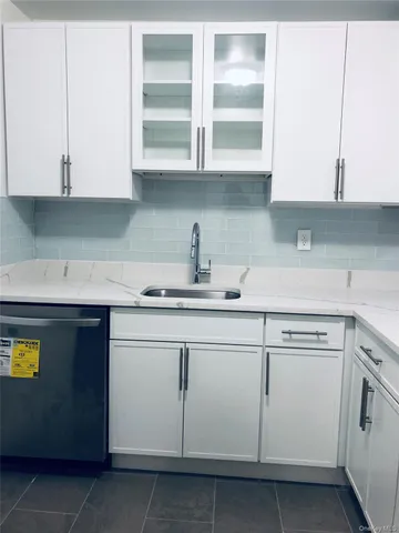 a kitchen with stainless steel appliances granite countertop white cabinets and a sink