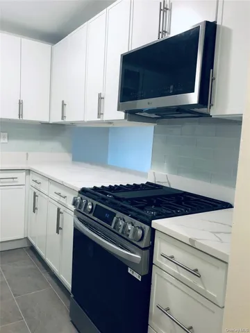a stove top oven sitting inside of a kitchen