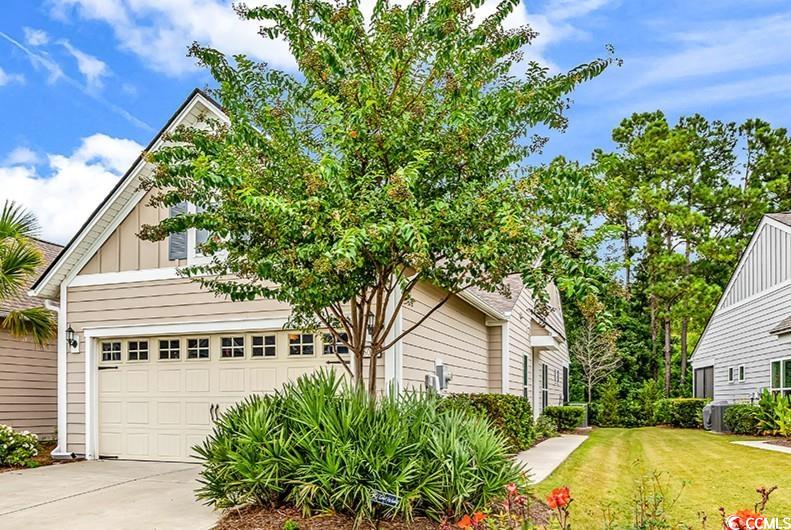 6013 Tramonto Street Myrtle Beach, SC 29577 - Photo 1 of 40 View of side of property featuring board and batten siding, a yard, a garage, and concrete driveway