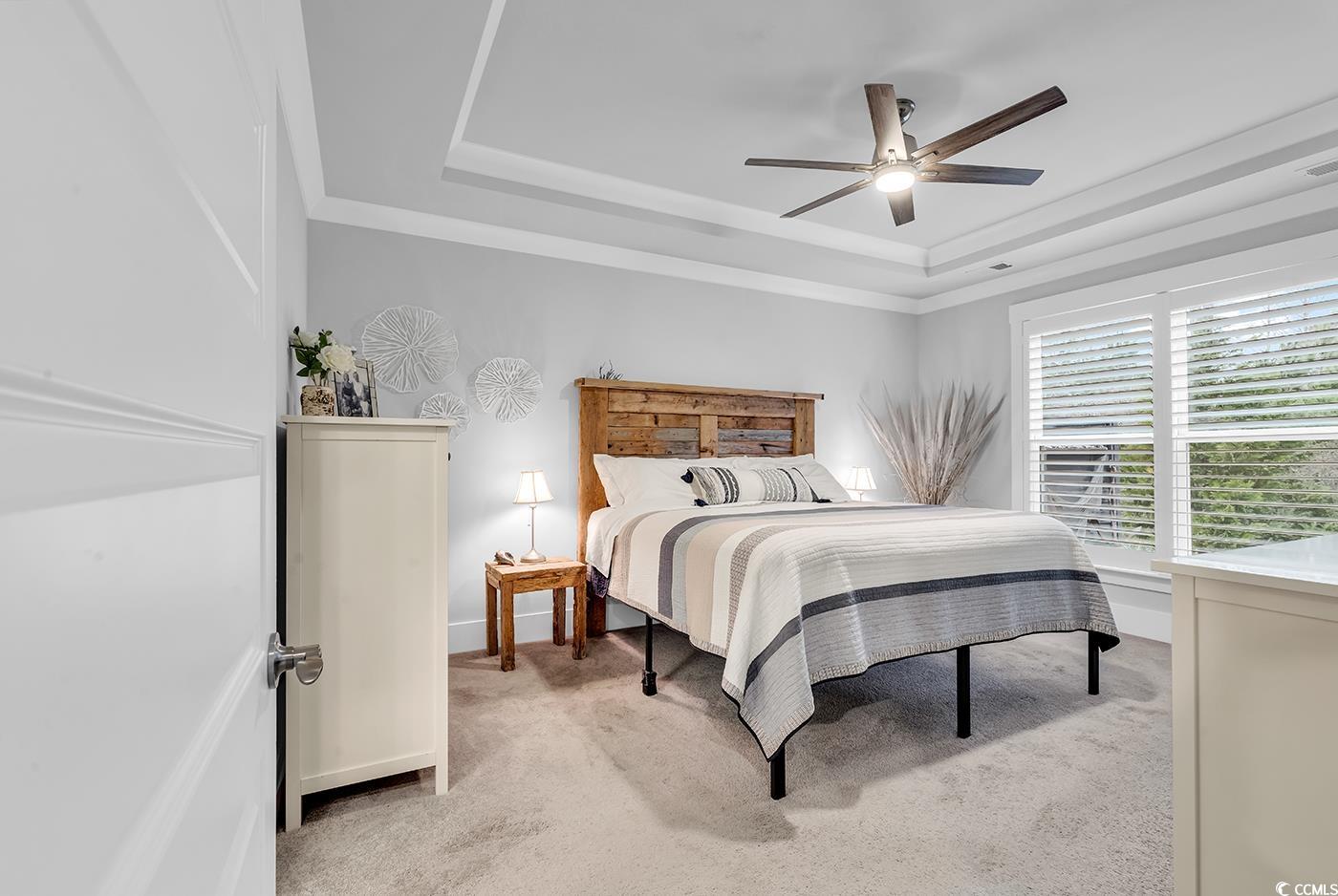 6013 Tramonto Street Myrtle Beach, SC 29577 - Photo 19 of 40 Bedroom with a raised ceiling, light colored carpet, a ceiling fan, and ornamental molding