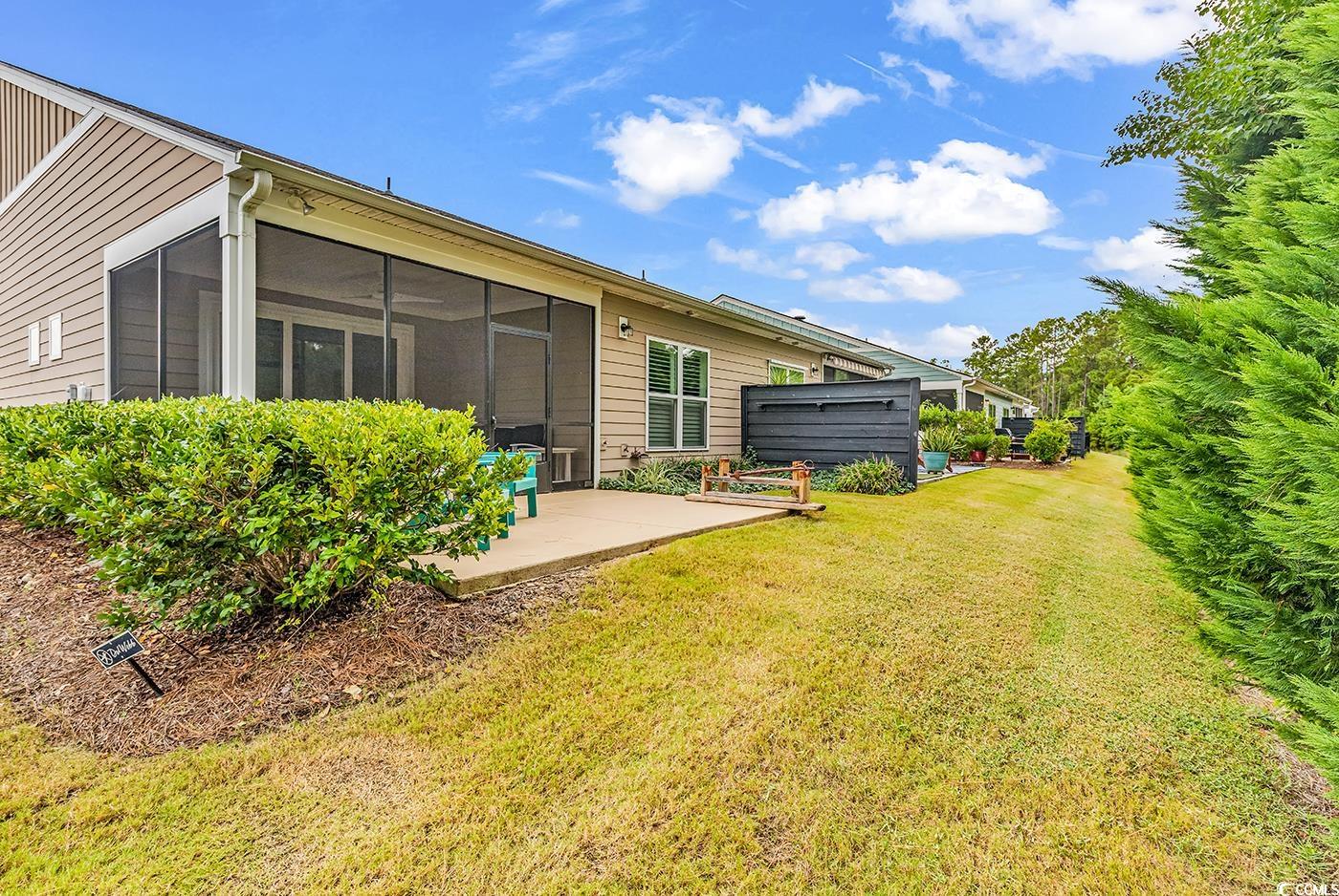 6013 Tramonto Street Myrtle Beach, SC 29577 - Photo 33 of 40 Rear view of house featuring a lawn and a sunroom