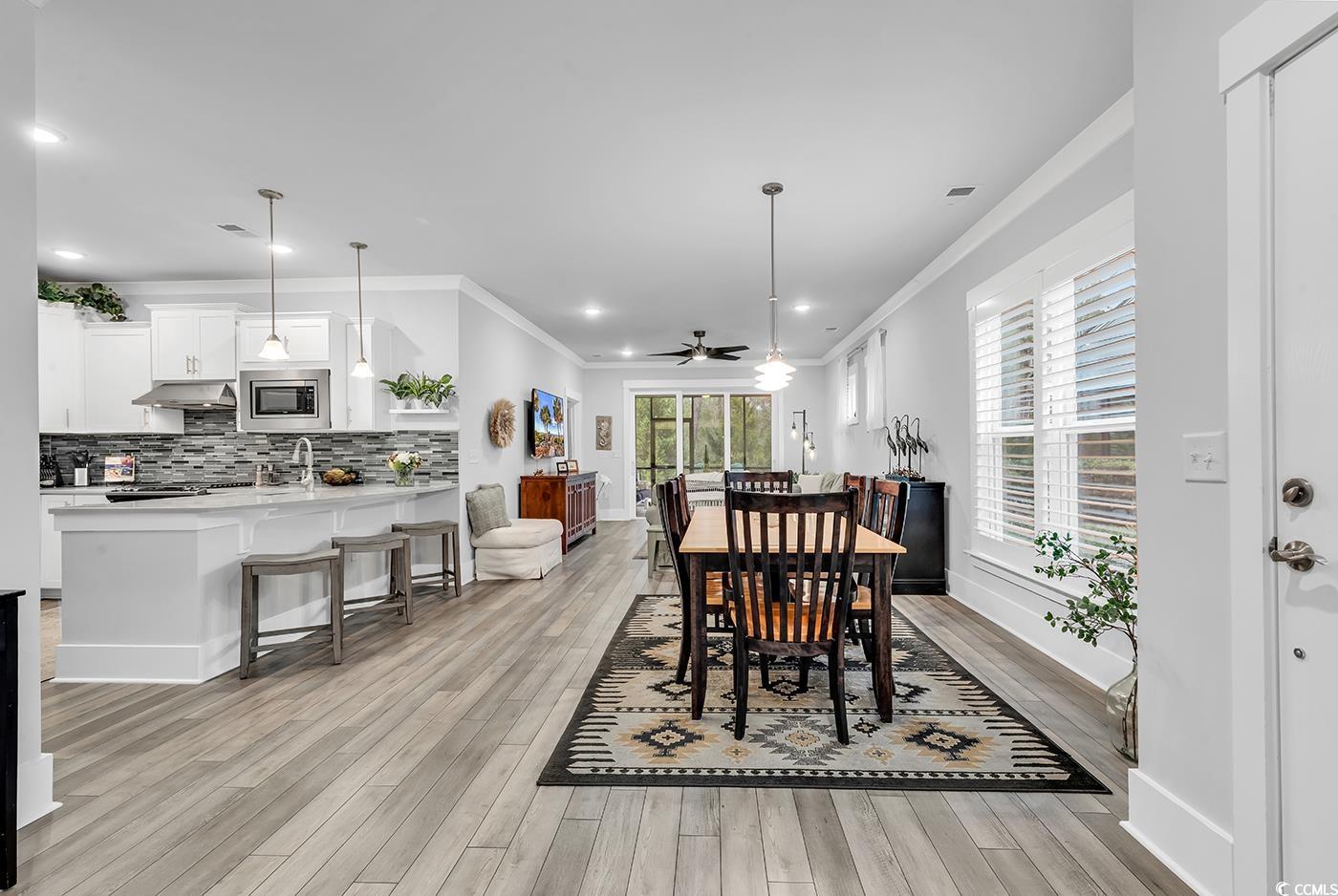 6013 Tramonto Street Myrtle Beach, SC 29577 - Photo 6 of 40 Dining space with crown molding, light wood-style flooring, plenty of natural light, recessed lighting, and a ceiling fan