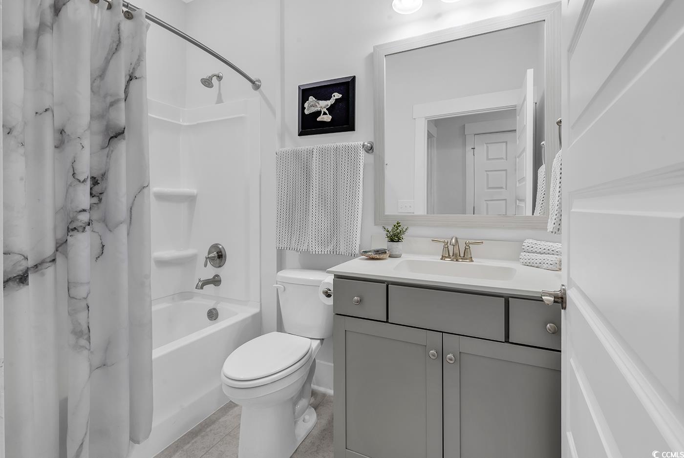 6013 Tramonto Street Myrtle Beach, SC 29577 - Photo 10 of 40 Bathroom featuring shower / bath combo with shower curtain, vanity, and light tile patterned floors