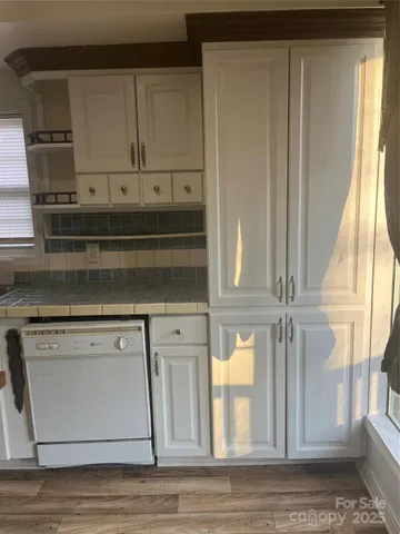 a kitchen with granite countertop white cabinets and white appliances