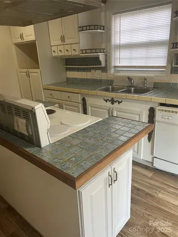 a kitchen with kitchen island granite countertop a sink and a stove