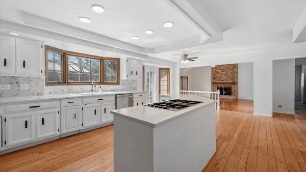 a kitchen with stainless steel appliances a stove a sink dishwasher and a refrigerator with wooden floor