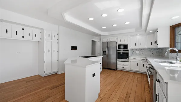 a kitchen with stainless steel appliances a refrigerator sink and white cabinets