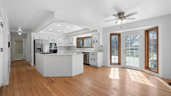 a view of kitchen with kitchen island wooden floor center island and stainless steel appliances