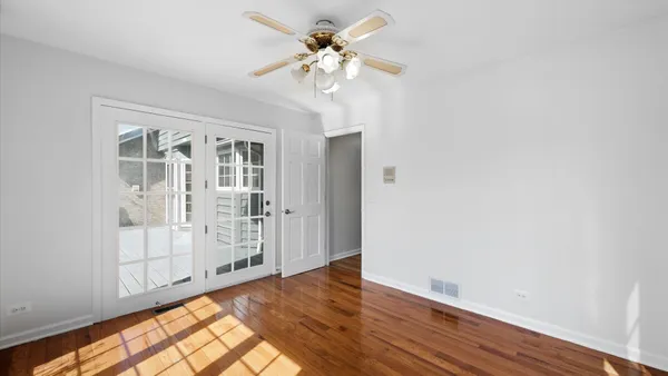 a view of a hallway with wooden floor and chandelier