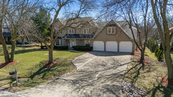 a front view of a house with a yard covered with snow