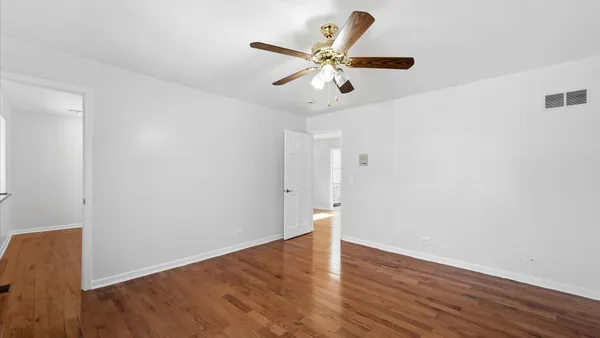 a view of a hallway with wooden floor and entryway