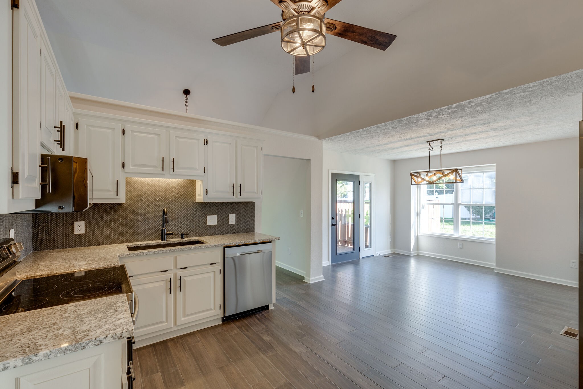 3648 Mahlon Moore Road Spring Hill, TN 37174 - Photo 13 of 30 a kitchen with stainless steel appliances a stove top oven a sink a window and wooden floors