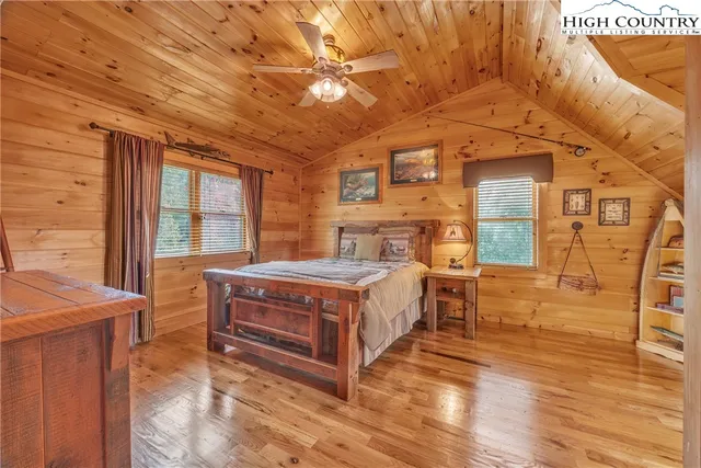 a spacious bedroom with a bed and wooden floors