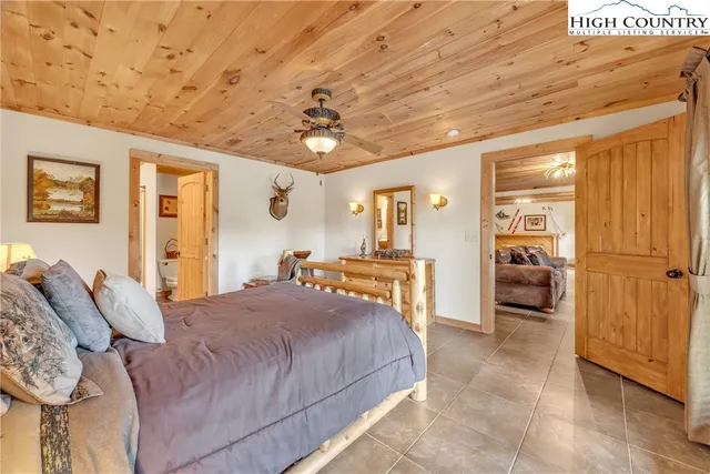 a bedroom with a large bed and a chandelier