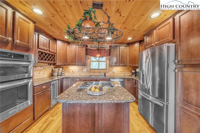 a kitchen with kitchen island granite countertop stainless steel appliances and a refrigerator