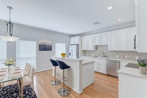 a kitchen with stainless steel appliances granite countertop white cabinets sink and granite counter tops